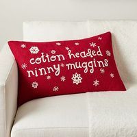 a red pillow that says cotton headed tiny mugins on it sitting on a white couch