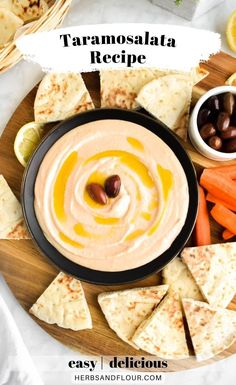 hummus with olives, carrots, and pita chips on a plate