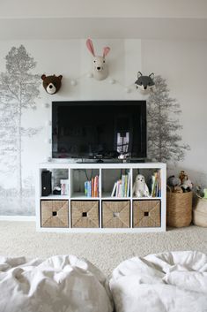 a white entertainment center with baskets and stuffed animals on the wall