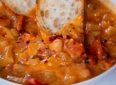 a close up of a bowl of food with bread sticking out of it