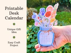 a hand holding a jar with flowers in it and the text printable desk calendar unique gift idea easy craft project