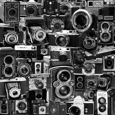 black and white photograph of many old cameras