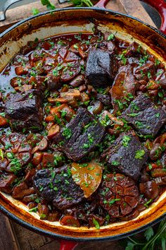 a pot filled with stew and vegetables on top of a wooden table