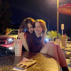 two women sitting at a table with drinks