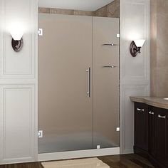 a bathroom with a walk in shower next to a sink and mirror on the wall