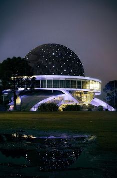 a large building lit up at night with stars on it's roof and windows