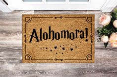 a welcome mat with the word alohomara written in black on it next to flowers