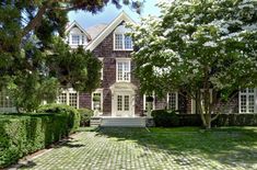 a large house surrounded by hedges and trees