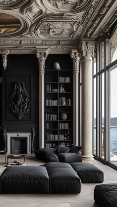 a living room filled with black furniture and lots of windows