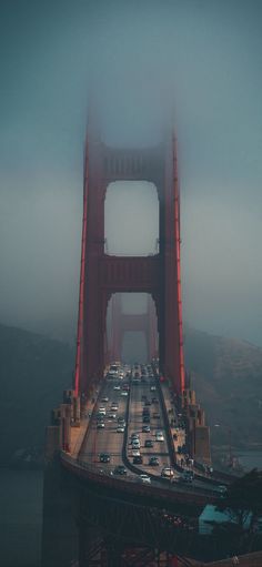 the golden gate bridge in san francisco, california on a foggy day with cars driving over it