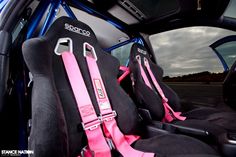 two seats in the back of a car with pink and black seat covers on them