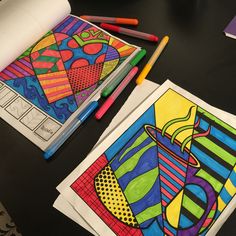 two coloring pages with markers and pencils on a table next to some art work