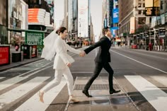 a newly married couple crossing the street in new york city, holding each other's hands