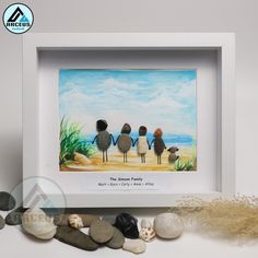 three birds are sitting on the beach in front of some rocks and seaweeds