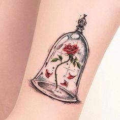 a tattoo on the leg of a woman with a rose in a glass bell jar