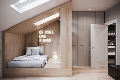 an attic bedroom with white walls and wood flooring, built into the side of a building