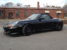 a black sports car parked in front of a brick building