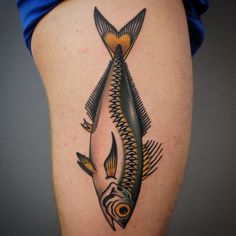 a fish tattoo on the side of a woman's leg