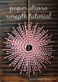 a paper straw wreath made out of red and white candy canes on top of a wooden