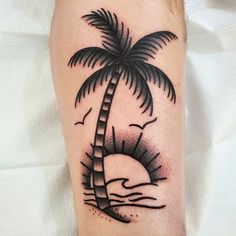 a black and white palm tree tattoo on the leg