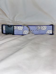 a blue and white striped dog collar on a bed