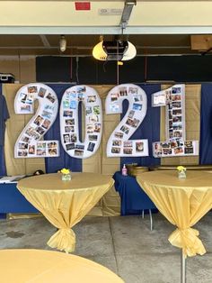 two tables covered in yellow tablecloths with pictures hanging on the wall behind them