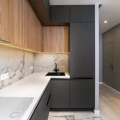 an empty kitchen with marble counter tops and wooden cabinetry on the walls, along with white counters