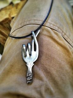 a close up of a silver fork on a leather cord