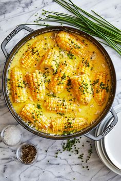 a skillet filled with corn on the cob and garnished with parsley