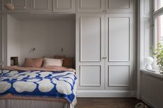 a bed sitting next to a window in a bedroom