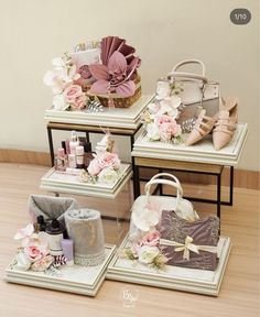 four wooden trays with flowers and personal care items on them sitting on the floor