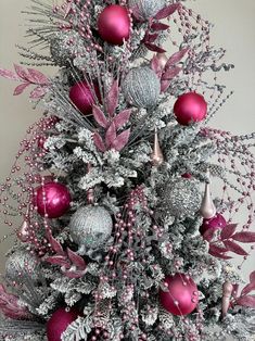 a silver and pink christmas tree with ornaments