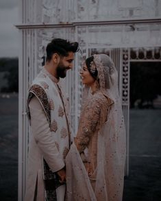 a bride and groom standing together in front of an ornate archway at their wedding ceremony