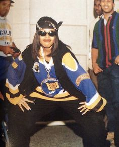 an old photo of a hockey player posing for a picture with other people in the background