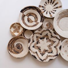 several woven baskets are arranged on a white surface with black and brown circles in the middle