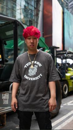 a man with red hair standing in front of a bus