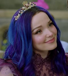 a close up of a person with blue hair wearing a tiara and looking at the camera