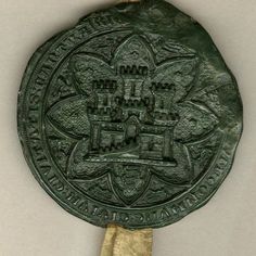 a green medal with an ornate design on it