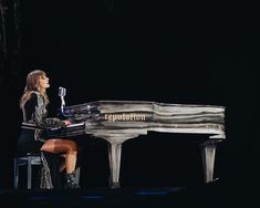 a woman sitting at a piano on stage