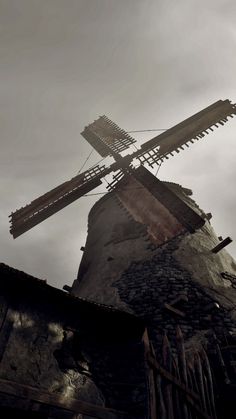 an old windmill is shown against a cloudy sky