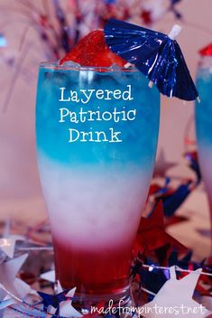 two glasses filled with red, white and blue drinks sitting on top of a table