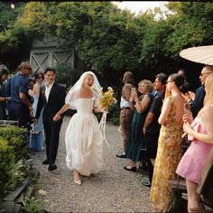 the bride and groom are walking down the path