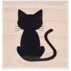 a wooden stamp with a black cat sitting on it's hind legs and tail