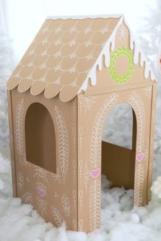 a small cardboard house sitting in the snow