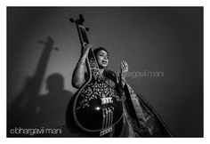 the woman is holding her guitar and looking up at the sky in black and white