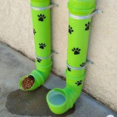 a pair of green boots with paw prints on them and a dog food dish in the bottom