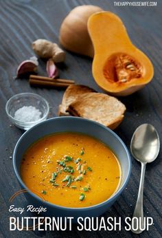 a bowl of butternut squash soup next to some bread