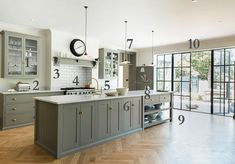 a large kitchen with wooden floors and gray cabinets