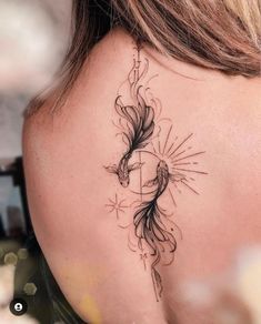 the back of a woman's neck with a tattoo design on her left shoulder