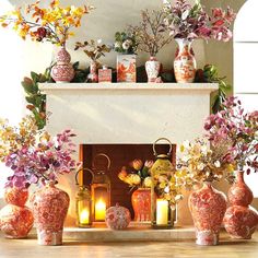 there are many vases with flowers in them on the mantel above the fireplace